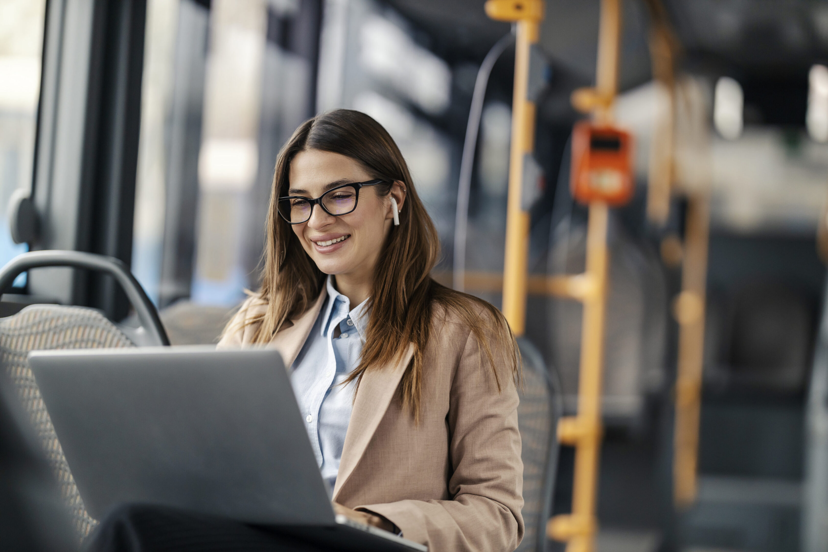 Woman working on laptop in bus