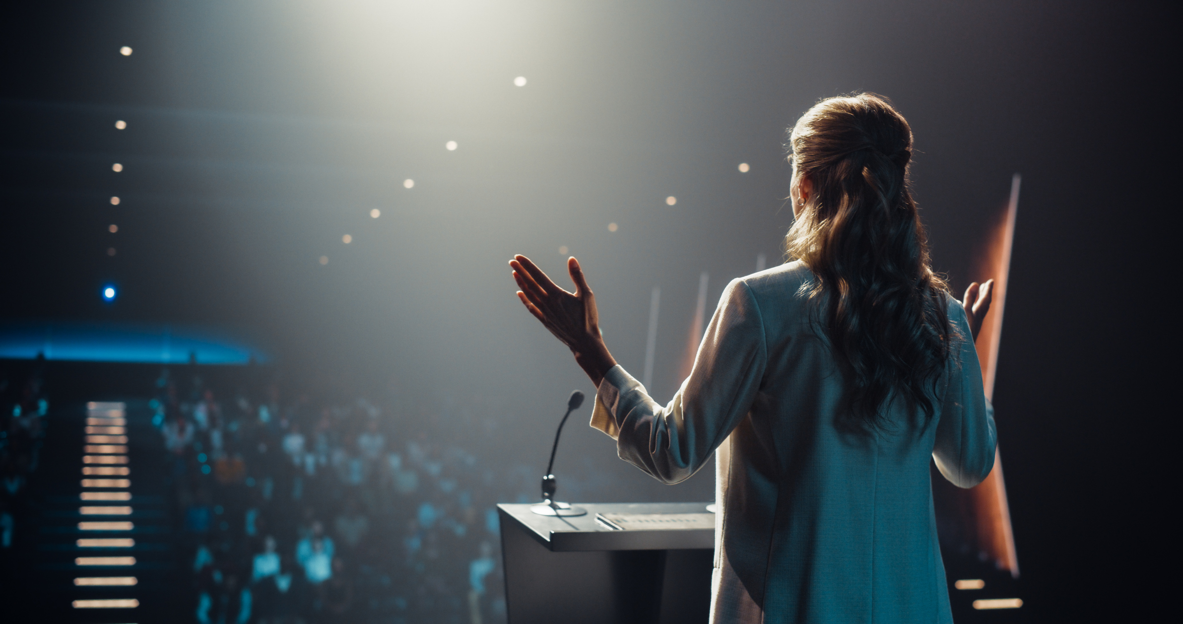 Woman giving speech at podium in auditorium